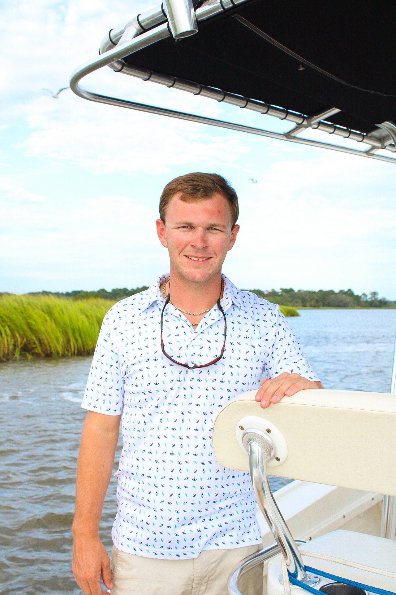 Captain of Triple M Charters at the helm on a Lowcountry creek at golden hour