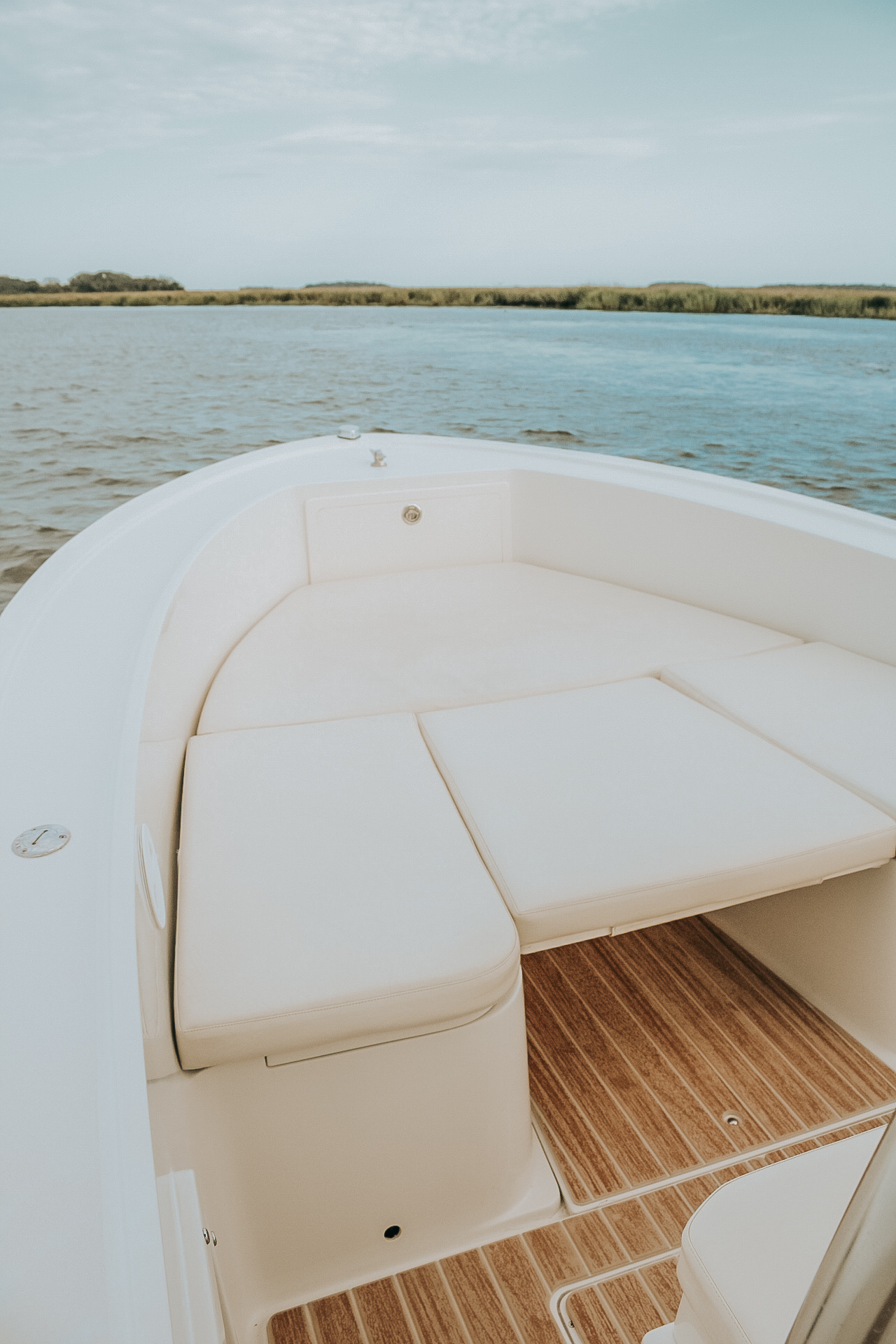 Cushioned bow seating on the Money Makin' Mako with the marsh behind